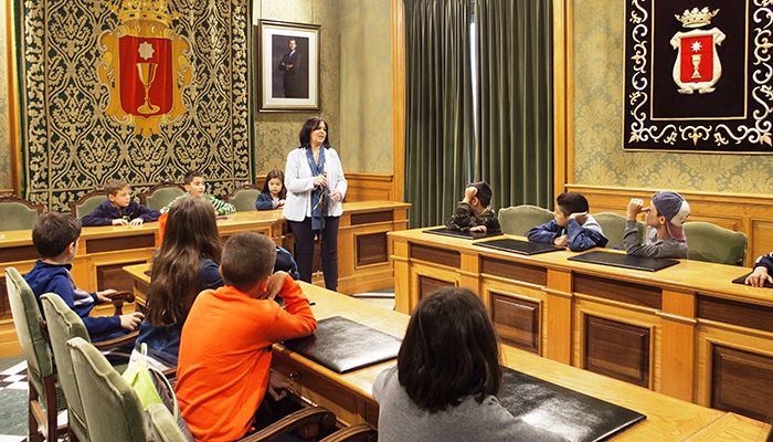 La concejal de Educación, Esther Martínez ha recibido en el Salón de Plenos a un grupo de más de 60 escolares de 4º de Primaria, participantes en un intercambio entre el Colegio La Milagrosa y el San Vicente de Paúl de Cartagena. Martínez ha explicado a los alumnos el funcionamiento del Ayuntamiento de Cuenca, el Pleno, su composición por los grupos políticos, cómo se toman las decisiones y ha contestado las numerosas preguntas que le han hecho los niños; éstos se han interesado especialmente por la historia del edificio municipal, cuya construcción se inició en 1760, reinando Carlos III. La concejal les ha mostrado el bastón y la medalla municipales; les ha entregado unos regalos y les ha deseado que disfruten mucho de su estancia en Cuenca. Los alumnos conquenses viajaron a la ciudad murciana en el mes de abril y ahora ha tocado conocer Cuenca, con visitas al Nacimiento del Río Cuervo, la Ciudad Encantada, el Hospital de Santiago, el Casco Antiguo, entre otros lugares.