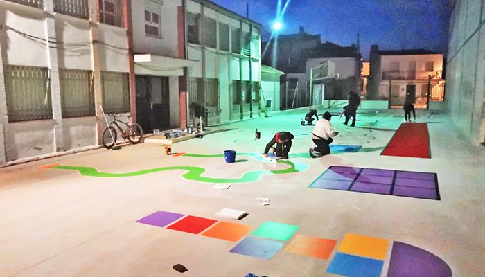 Padres y alumnos del colegio de Tinajas decoran el patio pintando en el suelo juegos tradicionales