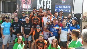 El domingo 1 de septiembre tuvo lugar la celebración de la VI Marcha MTB Cañizares “Serranía Activa” en la localidad Serrana de Cañizares, décimo tercera prueba puntuable del XII Circuito MTB “Diputación de Cuenca”, organizada por el C.D. MTB Cañizares y el Excmo. Ayuntamiento de Cañizares.  Desde el primer momento, en el control de firmas y entrega de dorsales a corredores acompañó una climatología excepcional, que iba a perdurar durante toda la carrera, lo que permitió a participantes disfrutar de un circuito en un estado excepcional y al público de este día festivo.  Este año, nuevamente, el CD MTB Cañizares estableció un reto deportivo solidario, consistente en la recaudación para APANID (Asociación de Padres de Niños Diferentes), de quien su vecino Alberto forma parte. Gracias a la solidaridad vecinal, empresas, mercadillo y donaciones, se logró la cantidad de 1368€ que fue entregado por el Presidente del Club a Eduardo Pallerola, Director del Centro Especial de Empleo de APANID.  Partiendo desde la Plaza de Santiago, en pleno centro de Cañizares, se disputa desde el primer momento un trazado con un marcado aire de atractivas sendas y caminos en zonas de arbolado y pinar más cerrado, así como alguna pista más ancha y sencilla en zona abierta, pero no menos dificultosa y de gran atractivo. Se pueden destacar los accesos y subidas del primer tercio de vuelta en la Cerca del Pincho y los Poyales, con pequeñas bancadas y estrechos accesos, así como las nuevas sendas recuperadas en torno al Km 5. No podemos dejar de citar una de las estampas más bonitas y descensos principales de la prueba que lleva hacia la ya conocida Senda del Gollindo, para encarar la entrada a Cañizares.  Estando los cajones y resto de corredores en posición, tras los habituales nervios y miradas cómplices y cruzadas, un agradecimiento y arenga precedía a las 10.00 con puntualidad, la salida a los 164 participantes que se congregaron.  Desde el primer momento se imprimió un buenísimo ritmo y marcha de mano de Adrián Plaza acompañado de Santiago Madrona y Álvaro Herraz. La segunda vuelta supuso el cambio de posiciones y terminó por confirmar el gran momento de forma del actual Campeón de España BTT XCO-XCE-TR en M-50 Santiago Madrona Tornero (ULBSPORTS TEAM), que con un tiempo de 1h25¨13” se alzaba por el primer puesto, con una ventaja de veinte segundos de diferencia sobre el segundo clasificado Adrián Plaza (TEAM PLAZA) con 01:25:33, y el tercero, algo más alejado, Álvaro Herraz Ferreros (NUTRIOBELIX) con 1h26´25”, dibujándose así el cajón de la general masculina.  El cajón de la general féminas fue el siguiente Lola Castellote (ROMERA BISTROT BIKE TEAM) con un tiempo de 1h39´35”, el segundo lugar lo ocupó la corredora local Yolanda Hellín (MTB CAÑIZARES) 2h02´35”, siendo tercera Marina María Martínez (SINGULAR BIKE VILLARROBLEDO) 2h15´58”. En Promesas, dominio de Luis Vilar (PC ARGUISUELAS), ocupando a poco menos de un minuto la segunda posición Iván Rodrigo (ROBLE BIKE). Tercer puesto para su compañero de equipo Francisco Javier Fernández (ROBLE BIKE).  En la categoría Féminas Élite, con un recorrido total de 34 km, primer puesto para incombustible Lola Castellote (ROMERA BISTROT BIKE TEAM), seguida de la corredora local Yolanda Hellín (MTB CAÑIZARES) ocupando el tercer lugar del cajón en esta categoría Marina María Martínez (SINGULAR BIKE VILLARROBLEDO).  La categoría Fémina Master estuvo dominada por Teresa Martínez (CLUB BTT SAN CLEMENTE), seguida de Gloria Soriano (CC UTIEL) y tercera posición para Ana Herrera (NUTRIOBELIX).  En categoría Élite, primer puesto del cajón para Álvaro Herraz (NUTRIOBELIX), seguido de Adrián Ortega (FINCA ANTIGUA-EL CASTILLEJO), tercera posición para el Guadajareño Santos Artiaga (UN PIÑÓN).  En Sub-23, primer puesto para Adrián Plaza (TEAM PLAZA), segundo puesto para Javier Arellano Plaza (CC AJO Y AGUA) y tercera posición para Juan Manuel Alarcón (FINCA ANTIGUA-EL CASTILLEJO).  Los Máster 30 tuvieron en el primer puesto para Alberto Brox (CLUB BTT SAN CLEMENTE), segunda posición para Francisco García (NUTRIOBELIX) y la tercera posición ocupara por Ángel García (MTB TARANCÓN).  En Máster 35 la primera posición para Emilio Santos (ULB SPORTS TEAM), la segunda posición para Óscar Chicharro (TT CARBÓN WHEELS) y la tercera posición ocupara por Diego Lorente (MTB MIRA).  El podio en Máster 40 lo formaron Andrés Almendros (LOS BRONCES CYCLING TEAM) en primera posición, segundo puesto para José Juan Valdés (FINCA ANTIGUA-EL CASTILLEJO) y tercera posición para Fernando Martínez (NUTRIOBELIX).  Los puestos de honor en Máster 45 fueron a manos de Sergio González (TT CARBON WHEELS), Isaac Villanueva y  Fernando Pérez (1 PIÑÓN).  Entre los Máster 50, en primer lugar cruzó la línea de meta Santiago Madrona (ULS SPORTS TEAM), seguido por Pedro Manuel Exojo (BELMONTE NATURE) y la tercera posición la ocupó Alberto Martín (FINCA ANTIGUA-EL CASTILLEJO).  En recorrido Promoción fémina, primera posición para Paula Plaza (TEAM PLAZA), segunda posición para Marta García (ENGLISH RIGHT NOW) ocupando la tercera posición la corredora local Aurora del Río (MTB CAÑIZARES).  El cajón Promoción masculino tuvo la siguiente composición: primera posición para Miguel Ortega (FINCA ANTIGUA-EL CASTILLEJO), segunda posición para Julián Ponce (NUTRIOBELIX) ocupando el tercer lugar del cajón su compañero de equipo José Andrés López (NUTRIOBELIX). En la clasificación por equipos subió a lo más alto del cajón el equipo NUTRIOBELIX, segunda posición para FINCA ANTIGUA-EL CASTILLEJO y la tercera posición para el equipo BTT SAN CLEMENTE.  Los tres participantes más veteranos premiados fueron Julián Jimenez (SPORTECNIC EQUIPAMIENTO DEPORTIVO), Manolo Jiménez y Josep María Mollá, ambos del (FINCA ANTIGUA-EL CASTILLEJO).  Se estableció categoría local en el recorrido corto, subiendo al cajón Elías Muñoz, Miguel Valiente y Raúl Martínez. Los premiados en el recorrido local largo fueron respectivamente, Juan Manuel Alarcón, Eduardo San Martín y Ernesto Arnao.  La entrega de premios corrió a cargo del alcalde de la localidad Julio César Bodoque, acompañado de varios miembros del club organizador.  La próxima prueba puntuable de este XII Circuito MTB de la Excma. Diputación Provincial de Cuenca, la número 14, denominado V Trofeo MTB Dinosaurios de Fuentes, tendrá lugar en la localidad de Fuentes el sábado día 14 de septiembre a las 16:30h.