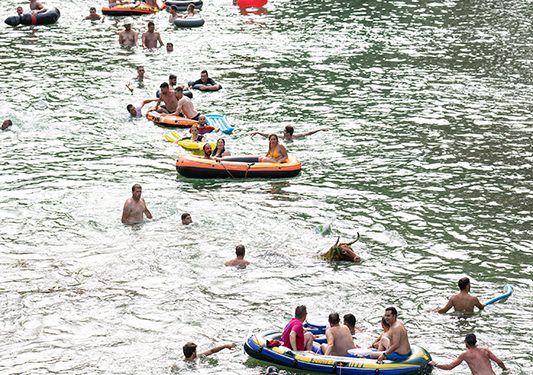 Las Vacas por el Tajo y la ola de calor llenan La Isla de corredores, bañistas, colchonetas y flotadores