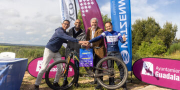 El Ayuntamiento de Guadalajara ha presentado junto con Witzenmanln ha presentado hoy la segunda edición del XCO Ciudad de Guadalajara, que se celebrará el próximo domingo 4 de mayo, en el circuito sobre el Mirador del Balconcillo, con salida y meta este año desde la ciudad, en la calle Salvador Dalí y que este año ya tiene categoría internacional. En el acto de presentación, que tuvo lugar en ese entorno natural del circuito, con un recorrido de 6.5 km con 200 m de desnivel por vuelta, han participado el concejal de Deportes, Armengol Engonga; el director de Witzenmann Española, Rafael Merinero; el presidente de Alcarreña de Ciclismo, Mario Alcivar; y Aurelio Mayoral, miembro del equipo de organización y uno de los deportistas en la prueba. Engonga subrayó este proyecto nació el año pasado gracias al Club de Ciclismo de Guadalajara, con la colaboración de la empresa Witzenmann Española y el Ayuntamiento de Guadalajara, “mejora su recorrido y contará con más de 500 ciclistas de montaña de este deporte olímpico". Además, expresó su agradecimiento a Rafael Merinero por su apoyo continuo en diversos proyectos deportivos y a Mario Alcivar por su dedicación en la formación de jóvenes ciclistas. Engonga también reconoció el trabajo de Aurelio Mayoral en la mejora del circuito y la incorporación de novedades para esta edición. “El II XCO Guadalajara promete ser un evento emocionante y de alto nivel, con la participación de destacados ciclistas y la incorporación de novedades que harán del circuito un espectáculo visual para todos los espectadores”, apuntó Engonga que invitó a todos los ciudadanos de Guadalajara a acercarse y disfrutar de esta gran prueba deportiva. Rafael Merinero, director de Witzenmann Española, destacó los valores que motivan a su empresa a apoyar iniciativas locales como el XCO Guadalajara. "Creemos en las iniciativas locales y en la promoción de los valores familiares y tecnológicos", afirmó Merinero. Subrayó que las bicicletas utilizadas en la prueba son de alta tecnología, lo que añade un valor adicional al evento. Merinero agradeció al Ayuntamiento y al Club de Ciclismo por su colaboración y deseó éxito a los participantes y espectadores. Por su parte, Mario Alcivar, presidente del Club de Ciclismo de Guadalajara, agradeció el apoyo recibido y destacó el crecimiento de la Escuela Alcarreña de Ciclismo desde su fundación en 2018. "Somos una familia que ama el deporte y trabaja para que los niños disfruten practicando ciclismo", comentó Alcivar. También detalló las categorías y horarios de las pruebas que se llevarán a cabo el domingo, incluyendo las pruebas máster, élite femenina, élite masculino y junior, y la prueba de escuela. Aurelio Mayoral, miembro del equipo de organización, explicó las mejoras implementadas en el circuito para esta edición. "Hemos incorporado el núcleo urbano de Guadalajara al recorrido y creado un circuito más seguro y técnico", señaló Mayoral. Destacó la participación de destacados ciclistas nacionales e internacionales y la inclusión de la prueba en el calendario de la Unión Ciclista Internacional (UCI). "Este año, la prueba es puntuable no solo para el ranking nacional y de Castilla-La Mancha, sino también para el internacional", añadió. Se espera la participación del campeón de España y medallista olímpico David Valero, que ya ha confirmado su inscripción; de David Campos, que es el subcampeón de España y ha sido campeón de Europa en el 2023. En distancia corta estará Nuria Bos Picó, líder de la Copa de España actualmente y primer Punto al Élite en féminas.