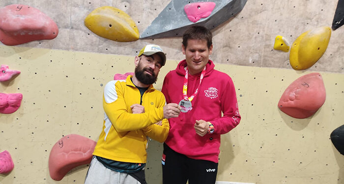 El Club Deportivo amiab sigue celebrando los éxitos de sus integrantes. En este caso, el deportista Sergio Aznárez Rosado, ciego y con Trastorno del Espectro Autista (TEA), ha firmado un segundo puesto en categoría B1 (ceguera total, pero que no contempla el autismo) en la Copa de España de Paraescalada, celebrada este sábado 26 de abril en Vic (Barcelona). Aznárez Rosado, quien solo ha estado en dos competiciones contando ésta, ha participado en la competición de la mano de la Federación de Deportes de Montaña, seleccionado con la Selección de Escalada de Castilla-La Mancha. Su entrenador, Pedro Almagro ‘Pantxo’, lo ha acompañado en esta cita de la que han regresado “muy contentos”. El sábado por la mañana en las rondas clasificatorias había dos vías: “Sergio subió la primera bastante bien y eso que para su categoría eran muy difíciles y a él le cuestan bastante, porque tienen mucho desplome y agarres no tan buenos como los que solemos entrenar, además de que no se tiene en cuenta que tiene TEA, algo que le influye también”, comenta Pantxo. Por la tarde, que eran las finales para las que él ya estaba clasificado, subió su vía, que era bastante complicada, pero también y para que pudiera disfrutar más, le dieron la opción de cambiar de vía a una más asequible. “Lo hizo muy bien, subió mucho y le faltaron solo cuatro o cinco presas para subir del todo”, explica su entrenador, quien añade que “el ambiente ha sido muy bueno, la gente muy acogedora, han estado muy pendientes de Sergio y yo creo que ha disfrutado mucho”. Pantxo asegura que le ha gustado la experiencia, “ha sido muy emocionante porque ves a tanta gente sin una mano, sin una pierna, con ceguera, escalando… y con Sergio he hecho un buen binomio, me ha hecho caso en todo, ha estado muy atento y, aunque tenemos que mejorar cosas, ha peleado mucho y la gente nos comentó que se había emocionado con su actuación”. La siguiente prueba será el 7 de junio en Mallorca, a la que también está previsto que asista el deportista de amiab.