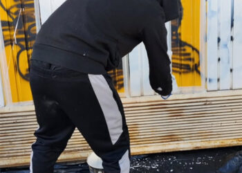 Un joven repara personalmente los daños de un grafiti en Cuenca