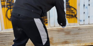 Un joven repara personalmente los daños de un grafiti en Cuenca