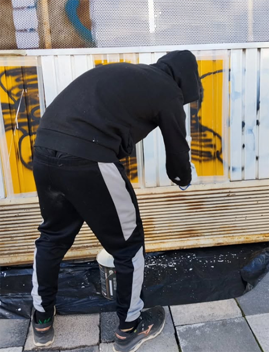 Un joven repara personalmente los daños de un grafiti en Cuenca