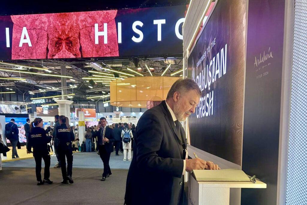 Dolz firma en el libro de condolencias de Adamuz en FITUR