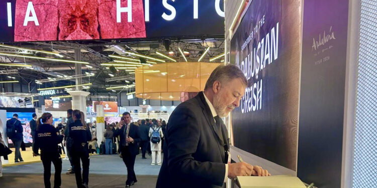 Dolz firma en el libro de condolencias de Adamuz en FITUR