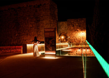 Cuenca es una de las provincias con mayor peso en la representación castellanomanchega en los Premios ARQUITECTURA 2026. De los ocho proyectos seleccionados por el Colegio Oficial de Arquitectos de Castilla-La Mancha, dos proceden de la capital conquense, y ninguna es una obra de relleno: la Pasarela del Arco de Bezudo y la CASA PARA A EN MdC representan dos maneras opuestas y complementarias de entender la arquitectura, la pública y la privada, la infraestructura patrimonial y la vivienda de autor. Los ganadores se conocerán el 9 de junio en el Teatro Alcázar de Madrid. Las dos apuestas conquenses Pasarela del Arco de Bezudo — Espacio Público | REDONDO ARCHITECTS El proyecto de los hermanos Javier y Miguel Ángel Redondo resuelve uno de los problemas históricos de accesibilidad en el Casco Antiguo de Cuenca: la conexión peatonal entre el Arco de Bezudo y el barrio del Castillo, sobre el foso. La pasarela, construida en acero corten, mide dos metros de ancho, discurre paralela al puente existente y en sus extremos incorpora dos miradores de cristal con vistas a la Hoz del Júcar y al lienzo de la muralla. El diseño también integra iluminación artística nocturna, y la inversión total rondó los 400.000 euros, financiados en parte con fondos Next Generation a través del Plan Impulsa Patrimonio del Grupo de Ciudades Patrimonio de la Humanidad. El alcalde Darío Dolz calificó el resultado como "magnífico" en el acto de inauguración, celebrado el 27 de agosto de 2025. La obra está concebida además como el primer paso de una actuación más amplia que incluirá la restauración del propio Arco de Bezudo, el foso y los tramos de muralla hasta casi Puerta de Valencia. CASA PARA A EN MdC — Edificación | Marcos Cortés Lerín La segunda propuesta conquense es radicalmente distinta en escala e intención. La CASA PARA A EN MdC, fotografiada por Fernando Alda, es un proyecto de vivienda de autor firmado por el arquitecto Marcos Cortés Lerín, cuya selección responde a los criterios del COACM sobre calidad espacial, sostenibilidad y arraigo al territorio. La fotografía de Fernando Alda, uno de los documentalistas de arquitectura más reconocidos de España, es ya un indicio de la carga visual y conceptual del proyecto. Contexto y archivo La selección de la pasarela del Arco de Bezudo en unos premios nacionales no es una sorpresa si se sigue la trayectoria reciente de la obra: su inauguración en agosto de 2025 generó atención mediática y técnica precisamente por combinar accesibilidad, integración patrimonial y diseño contemporáneo en uno de los entornos más delicados de la ciudad. Que ahora compita en la categoría de Espacio Público frente a propuestas de toda España confirma que la apuesta del Ayuntamiento de Cuenca por una arquitectura de calidad en el Casco Antiguo está obteniendo reconocimiento profesional más allá del ámbito local. El certamen, organizado por el CSCAE con patrocinio de COMPAC®, suma en esta edición un récord de 534 candidaturas, de las que 209 han pasado a la segunda fase. Los finalistas se conocerán en mayo y la entrega de premios tendrá lugar el 9 de junio en Madrid.