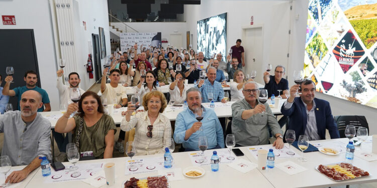Con motivo de la efeméride universal del Día de Libro, este 23 de abril, el Consejo Regulador celebró en el edificio Vinos del Quijote de Alcázar de San Juan, Cervanvino 2026. Una cita que, en palabras de Ángel Ortega, “pretende ser un homenaje a Cervantes y el Siglo de Oro donde el vino tenía una importancia especial en La Mancha y en Madrid”. El el propio gerente del Consejo Regulador dirigió la cata que tuvo una introducción histórica, a cargo de Juanjo Mazuecos, responsable del departamento de comunicación del CRDO La Mancha, donde se realizó un recorrido evolutivo de la cultura del vino en los pueblos de Mediterráneo, desde las fuentes clásicas de ascendencia grecolatina hasta los textos con referencias directas al vino en los escritores más insignes del Siglo de Oro como Quevedo, Lope de Vega incluso Shakespeare y por supuesto, Cervantes. En una cata dinámica, trufada con vídeos de animación por IA, y textos clásico del Siglo de Oro, los asistentes pudieron comparar los vinos actuales amparados bajo la Denominación de Origen La Mancha como sus blancos Airén, tintos jóvenes o crianza Cencibel, con aquellos vinos recreados que pudieran haber tomado en las tabernas del Siglo de Oro. El Quijote, legado universal La iniciativa contó con la participación de la Sociedad Cervantina de Alcázar de San Juan, cuyo Presidente, Juan Bautista Mata, aprovechó la ocasión para recordar el proyecto anhelado por su asociación para promover en la Unesco a los personajes literarios de Don Quijote y Sancho Panza como patrimonio inmaterial de la humanidad. “Para el 2027 sería el momento oportuno para conseguirlo porque sin agravio comparativo con otras propuestas culturales entendemos que hay pocas cosas más universales que el Quijote y su legado”. No en vano, emblema universal y embajador en el exterior, el Quijote representa el marchamo de calidad de los vinos con Denominación de Origen La Mancha. Su silueta le ayuda a abrir las puertas en mercados como China o Japón donde la novela del hidalgo caballero es un libro de cabecera.