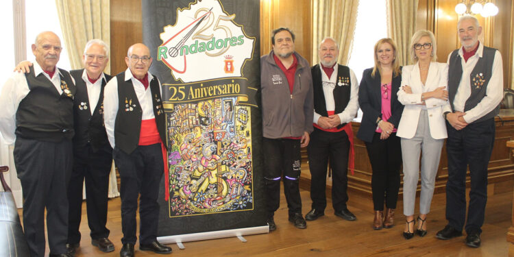 La Diputación Provincial de Cuenca ha sido el escenario elegido para desvelar la programación del 25 aniversario del Grupo Rondadores. Esta agrupación, nacida en 2001, lleva un cuarto de siglo dedicada a la recuperación y difusión de la música tradicional conquense. Durante la presentación en el salón de plenos, autoridades locales y provinciales han respaldado una trayectoria que ha permitido devolver a las calles tradiciones populares casi olvidadas. El presidente del colectivo, Fernando López Gabaldón, ha agradecido este apoyo institucional como pilar fundamental para alcanzar esta efeméride cultural. Para celebrar este hito, el Grupo Rondadores ha organizado un ciclo de conciertos temáticos en la capital que arrancará con una gran gala. El primer evento tendrá lugar este viernes 22 de mayo a las 20:00 horas en el Teatro Auditorio José Luis Perales, con entrada libre hasta completar el aforo. Las siguientes citas musicales están programadas para distintos espacios de la ciudad: Parque de San Julián el 23 de agosto. Salón de Actos de Unicaja el 30 de octubre. Centro Cultural Aguirre durante las fiestas de Navidad. El acto también ha servido para presentar el cartel oficial del aniversario. El artista conquense Tomás Bux ha sido el encargado de diseñar una obra que fusiona la arquitectura típica de Cuenca con los instrumentos tradicionales que caracterizan a la agrupación. Tanto la vicepresidenta segunda de la Diputación, Marian Martínez, como la delegada de la Junta en Cuenca, Marian López, han coincidido en el inmenso valor social del grupo. Ambas responsables han destacado las visitas de la agrupación a residencias de mayores y su labor fundamental para transmitir la cultura folclórica a las nuevas generaciones. Un legado musical vivo La trayectoria del Grupo Rondadores entronca directamente con el renacimiento del folclore en la provincia durante las últimas décadas. Tal y como documenta el archivo histórico de Liberal de Castilla, celebraciones como el tradicional Canto de los Mayos han experimentado un notable repunte de participación ciudadana en los últimos años. Esta revitalización no es un fenómeno casual, sino el fruto del trabajo constante de agrupaciones locales que han sacado los instrumentos tradicionales de los museos para devolverlos a las plazas y los barrios conquenses. El paso de cantar de forma improvisada en las calles a llenar espacios escénicos de primer nivel demuestra la consolidación de la música popular en Cuenca. La conservación del patrimonio sonoro ha dejado de ser una labor exclusiva de investigadores para convertirse en un elemento dinamizador de la vida diaria en Castilla-La Mancha. Al integrar la música tradicional en la agenda oficial, la ciudad asegura que el legado de las rondallas siga resonando con fuerza frente a los nuevos hábitos de consumo cultural.