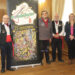 De las calles al Auditorio: Cuenca celebra los 25 años del Grupo Rondadores con cuatro conciertos 3 La Diputación Provincial de Cuenca ha sido el escenario elegido para desvelar la programación del 25 aniversario del Grupo Rondadores. Esta agrupación, nacida en 2001, lleva un cuarto de siglo dedicada a la recuperación y difusión de la música tradicional conquense. Durante la presentación en el salón de plenos, autoridades locales y provinciales han respaldado una trayectoria que ha permitido devolver a las calles tradiciones populares casi olvidadas. El presidente del colectivo, Fernando López Gabaldón, ha agradecido este apoyo institucional como pilar fundamental para alcanzar esta efeméride cultural. Para celebrar este hito, el Grupo Rondadores ha organizado un ciclo de conciertos temáticos en la capital que arrancará con una gran gala. El primer evento tendrá lugar este viernes 22 de mayo a las 20:00 horas en el Teatro Auditorio José Luis Perales, con entrada libre hasta completar el aforo. Las siguientes citas musicales están programadas para distintos espacios de la ciudad: Parque de San Julián el 23 de agosto. Salón de Actos de Unicaja el 30 de octubre. Centro Cultural Aguirre durante las fiestas de Navidad. El acto también ha servido para presentar el cartel oficial del aniversario. El artista conquense Tomás Bux ha sido el encargado de diseñar una obra que fusiona la arquitectura típica de Cuenca con los instrumentos tradicionales que caracterizan a la agrupación. Tanto la vicepresidenta segunda de la Diputación, Marian Martínez, como la delegada de la Junta en Cuenca, Marian López, han coincidido en el inmenso valor social del grupo. Ambas responsables han destacado las visitas de la agrupación a residencias de mayores y su labor fundamental para transmitir la cultura folclórica a las nuevas generaciones. Un legado musical vivo La trayectoria del Grupo Rondadores entronca directamente con el renacimiento del folclore en la provincia durante las últimas décadas. Tal y como documenta el archivo histórico de Liberal de Castilla, celebraciones como el tradicional Canto de los Mayos han experimentado un notable repunte de participación ciudadana en los últimos años. Esta revitalización no es un fenómeno casual, sino el fruto del trabajo constante de agrupaciones locales que han sacado los instrumentos tradicionales de los museos para devolverlos a las plazas y los barrios conquenses. El paso de cantar de forma improvisada en las calles a llenar espacios escénicos de primer nivel demuestra la consolidación de la música popular en Cuenca. La conservación del patrimonio sonoro ha dejado de ser una labor exclusiva de investigadores para convertirse en un elemento dinamizador de la vida diaria en Castilla-La Mancha. Al integrar la música tradicional en la agenda oficial, la ciudad asegura que el legado de las rondallas siga resonando con fuerza frente a los nuevos hábitos de consumo cultural.