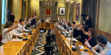 El Pleno Extraordinario del Ayuntamiento de Cuenca ha aprobado hoy por unanimidad el nombramiento a título póstumo de José María Cruz Novillo, artista y diseñador clave a nivel nacional e internacional, como Hijo Predilecto de la ciudad, el cual ya había anunciado el alcalde Darío Dolz tras habérselo dado a conocer a su hijo Pepe Cruz. La concejala de Cultura, María Ángeles Martínez, ha puesto en valor su figura, haciendo un recorrido por la faceta profesional de este artista internacional que nació en Cuenca en 1936 y comenzó su andadura artística entrando como dibujante en Publicidad Clarín en 1957, faceta que ya nunca abandonó. Posteriormente creará su propio estudio de Diseño, desde el que ideará las imágenes corporativas de instituciones y empresas como Correos, Tesoro Público, PSOE, COPE, Grupo PRISA, Diario 16, El Mundo, El Economista, Red Eléctrica, Renfe, Visionlab, Fundación ONCE o el logo de Cuenca 2016, entre muchos otros muy reconocibles. Fue presidente de la Asociación Española de Profesionales del Diseño (AEPD), convirtiéndose en Socio de Honor de la misma, y ha participado como jurado en decenas de premios, incluyendo los Premios Nacionales de Diseño, de Arquitectura y de Cómic. Ha diseñado también múltiples carteles de reconocidas películas y realizado multitud de exposiciones. En 2019 se estrenó la película documental ‘El hombre que diseñó España’, que repasa la trayectoria de Cruz Novillo tanto en su faceta de diseñador como en la de artista plástico desde su primer logo, en 1957, y exposición individual, en 1972. En la ciudad contamos en su honor con la Escuela de Arte Cruz Novillo, centro público de enseñanzas artísticas ubicado en el Casco Antiguo de la ciudad.