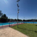 El Ayuntamiento de Azuqueca de Henares ha instalado seis nuevas cámaras de videovigilancia en el recinto de la piscina municipal de verano. Esta medida impulsada por la Concejalía de Seguridad Ciudadana, que ya se encuentra plenamente operativa, busca erradicar los actos vandálicos sufridos en las instalaciones durante los últimos años. Según detalla el concejal del área, Antonio Expósito, estos destrozos recurrentes han generado molestias evidentes a los bañistas y un gasto económico constante para las arcas municipales encargado de las reparaciones. Para solucionar este problema de raíz, el consistorio ha realizado una inversión aproximada de 15.000 euros en la adquisición de estos equipos de grabación. El sistema de seguridad cuenta con un protocolo estricto diseñado para proteger la privacidad de los vecinos de Azuqueca. Los dispositivos permanecen completamente desactivados durante el horario de apertura al público y solo entran en funcionamiento desde la tarde-noche hasta la mañana siguiente, periodo en el que la instalación permanece cerrada. Las imágenes captadas se transmiten en tiempo real y de forma exclusiva a las dependencias de la Policía Local para garantizar una monitorización inmediata. Una vez que la temporada de baño concluya el próximo 31 de agosto, las cámaras no quedarán inactivas, sino que se reubicarán estratégicamente en el perímetro del complejo deportivo San Miguel para reforzar la vigilancia de ese entorno de cara al invierno. Evolución del mapa de videovigilancia en Azuqueca La protección de la piscina municipal supone un paso más dentro de la extensa red tecnológica de seguridad ciudadana que se está desplegando en el Corredor del Henares. Repasando la hemeroteca reciente de Liberal de Castilla, observamos cómo Azuqueca ha consolidado durante el último año una estrategia integral de vigilancia que ya suma 120 cámaras activas distribuidas por las principales calles y puntos de acceso de la ciudad. Esta evolución hacia la seguridad preventiva, que complementa el patrullaje tradicional en los barrios, refleja un cambio de paradigma en la gestión policial local. A esta red fija de cámaras se sumó también la creación de la Unidad de dron de la Policía Local, documentada previamente en este medio, que permite controles aéreos rápidos en zonas de difícil acceso. De este modo, la reciente inversión de 15.000 euros en el recinto de verano no es una medida aislada, sino la continuación lógica de un plan a largo plazo destinado a disuadir los daños al patrimonio público y aportar pruebas visuales clave para el esclarecimiento de delitos en el municipio.