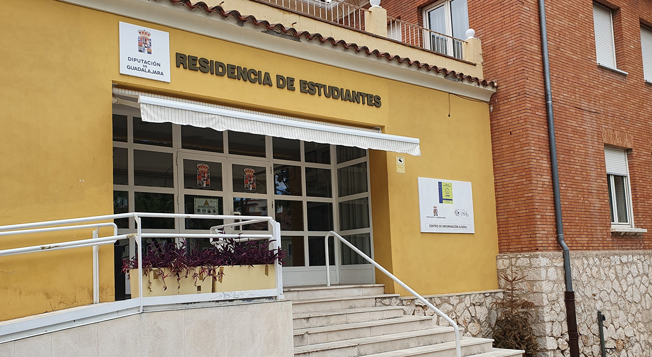 Los jóvenes de los pueblos de Guadalajara tendrán más plazas y precios congelados en la residencia de la Diputación 2 La Diputación de Guadalajara ha abierto el plazo para solicitar una de las 101 plazas de su Residencia de Estudiantes de cara al curso académico 2026-2027. Esta cifra supone un incremento del 20% en la capacidad de alojamiento respecto al año anterior, repartiéndose en 41 habitaciones individuales y 60 dobles. Las bases de la convocatoria, publicadas el pasado viernes en el Boletín Oficial de la Provincia, establecen un plazo de 15 días hábiles para presentar las solicitudes.A pesar de la ampliación de capacidad, la institución provincial ha decidido mantener intactas las tarifas del curso pasado. Los alumnos pagarán 379,88 euros al mes por una habitación individual y 340,30 euros mensuales si optan por la doble. Las plazas están destinadas a quienes cursen estudios universitarios, de postgrado, Bachillerato o ciclos formativos en la ciudad de Guadalajara, en la Universidad de Alcalá o en Madrid.Para garantizar la igualdad de oportunidades en el ámbito rural, el proceso de adjudicación sigue un sistema de prioridades muy definido:Estudiantes empadronados en la provincia que ya fueron residentes en años anteriores.Jóvenes de la provincia de Guadalajara que acceden por primera vez, dando prioridad a los que viven en los municipios más alejados de la capital.Alumnos con plaza en el curso 2025-2026, aunque no estén empadronados en la provincia.Residentes en otros municipios de Castilla-La Mancha, priorizando la cercanía a Guadalajara.Estudiantes del resto de España, también con preferencia de proximidad geográfica.Los trámites pueden realizarse a través de la sede electrónica de la corporación provincial, de forma presencial en las oficinas del Registro Electrónico (de 9 a 14 horas) o mediante correo certificado. Los estudiantes que resulten admitidos tendrán que confirmar su plaza entre el 15 de agosto y el 4 de septiembre de 2026.El salto cuantitativo frente al curso anterior
La revisión del archivo de Liberal de Castilla confirma el esfuerzo continuado de la Diputación por reforzar el escudo social para los estudiantes del medio rural. El salto de las 84 plazas que conformaban la oferta en el curso 2025-2026 a las 101 actuales marca la mayor ampliación habitacional reciente en estas instalaciones. Esta política de expansión, sumada a la congelación ininterrumpida de las cuotas mensuales, consolida la residencia como una herramienta fundamental para evitar que la distancia geográfica impida a los jóvenes de comarcas como la Alcarria o la Sierra acceder a la educación superior en igualdad de condiciones.