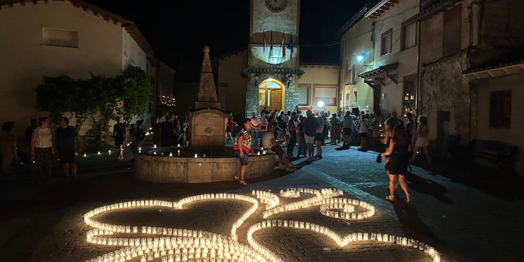 El municipio de Arbancón, en la provincia de Guadalajara, celebrará los próximos sábados 18 y 25 de julio la décima edición de "A La Luz de las Velas". Este evento transformará el casco histórico de la localidad apagando el alumbrado público para encender miles de velas en sus calles, plazas y fachadas. La iniciativa busca dinamizar el turismo de interior y poner en valor el patrimonio rural mediante una experiencia inmersiva que combina historia, música y gastronomía local. La programación estructurada para ambas jornadas ofrece diferentes propuestas: La jornada arranca a las 20:30 horas con puertas abiertas en los museos locales y la iglesia de San Benito Abad. Los visitantes encontrarán puestos de artesanía y productos gastronómicos distribuidos por todo el recorrido. La organización ofrece una visita guiada acompañada de una degustación de mieles autóctonas de la zona. Un recital poético sirve como preludio al gran encendido oficial programado a las 22:00 horas. La noche concluye con un concierto musical y una ruta nocturna enfocada en las leyendas del municipio. Evolución del evento El archivo de Liberal de Castilla muestra cómo esta cita ha evolucionado significativamente desde sus primeras ediciones. Lo que comenzó como una propuesta local para iluminar las noches de verano ha crecido de manera constante durante la última década. Los registros históricos del medio reflejan que la afluencia sostenida de visitantes obligó a la organización a profesionalizar el formato, introduciendo estrictos controles de aforo, venta anticipada de entradas y paquetes con experiencias turísticas cerradas. Esta trayectoria de diez años explica la actual consolidación de Arbancón como destino de referencia estival en Castilla-La Mancha. La decisión de exigir reserva previa a través de su portal web oficial preserva la esencia del municipio frente a la masificación, garantizando una visita de calidad. Al integrar a productores de la comarca y mantener el foco en la divulgación del entorno rural, la cita logra un equilibrio sólido entre el desarrollo económico y la protección de su identidad cultural.