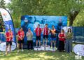 El Club Deportivo Atletismo Tarancón ha protagonizado un excelente estreno como organizador dentro del X Circuito Provincial de Duatlón y Triatlón de la Diputación de Cuenca. Más de 80 deportistas se dieron cita en el recinto de las Piscinas Municipales para disputar el III Triatlón "Ciudad de Tarancón", una prueba que se saldó con un rotundo éxito organizativo y la victoria por equipos del club anfitrión. La competición arrancó con un segmento de 300 metros de natación, seguido de 20 kilómetros de ciclismo a lo largo de la avenida Adolfo Suárez y concluyó con la carrera a pie por el entorno de la avenida Reina Sofía y el Parque de las Rejas. La jornada destacó por la seguridad y la coordinación logística, respaldada por el Ayuntamiento de Tarancón, la Policía Local, Protección Civil y un amplio dispositivo de voluntarios locales. En el plano deportivo, la prueba absoluta masculina fue dominada por José Enrique Aroca, del Club Triatlón Villarta, quien cruzó la meta con un tiempo de 47:53. En la categoría femenina, Irene de la Torre impuso su ritmo y se llevó la victoria para el CD Atletismo Tarancón al detener el cronómetro en 1:04:25. El medallero local se completó con un dominio claro en las distintas categorías de la jornada: Categoría Senior: José Enrique Aroca (C.T. Villarta) e Irene de la Torre (CD Atletismo Tarancón) lograron el oro, acompañados en el podio por atletas como Jesús García, Javier Haering y Sara Toledo. Categoría Veterano: Javier Cerrillo (C.T. Villarta) y Patricia Peral (C.T. Villarta) se alzaron con los primeros puestos. Categoría Máster: Raúl García Martínez (CD Atletismo Tarancón) y Mercedes Millán Burón (CD Atletismo Tarancón) lideraron la clasificación. Categoría Junior: Óscar de la Ossa López (CD Atletismo Tarancón) consiguió la primera posición. Competición por parejas y tríos: Los hermanos Jorge Díaz Lorenzo y Jorge Díaz Salto (CDA Tarancón) ganaron en parejas, mientras que el equipo C2 Wellness Boutique lideró la modalidad de tríos. La consolidación del triatlón en la provincia El análisis de la hemeroteca de Liberal de Castilla revela la importante evolución de esta disciplina en la provincia durante la última década. El Circuito Provincial de Duatlón y Triatlón, que este año celebra su décima edición, nació con el objetivo de vertebrar el deporte en las distintas comarcas conquenses. Históricamente, pruebas pioneras fueron abriendo camino, pero la incorporación de Tarancón al calendario subraya un salto cualitativo en la infraestructura deportiva local. La celebración de esta tercera edición del "Ciudad de Tarancón" marca un punto de inflexión para el CD Atletismo Tarancón. Tras años de crecimiento continuo en el número de federados y participaciones en eventos de la región, el club demuestra ahora su capacidad operativa asumiendo la organización integral de una cita oficial. Este paso no solo consolida al municipio como un referente deportivo de primer nivel en Castilla-La Mancha, sino que asegura el relevo generacional en un circuito que sigue batiendo récords de inscripción. La entrega de trofeos y productos típicos de la comarca contó con la presencia de autoridades como la diputada provincial Eva García, la primera teniente de alcalde Riansares López y el concejal de Deportes José Vicente Hontana, junto a la directiva del club local. El circuito provincial continuará su marcha el próximo 25 de julio con el III Triatlón de Quintanar del Rey.