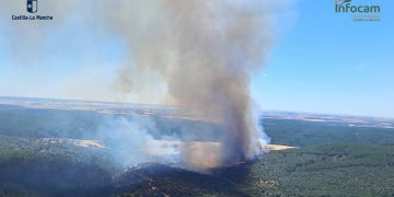 Un incendio forestal declarado este mediodía en el término municipal de La Mierla, en la provincia de Guadalajara, ha obligado a activar el Nivel 1 de emergencia. La medida técnica se ha tomado ante la posible afección por humo tanto a la población local como a importantes vías de comunicación de la zona. En concreto, las autoridades vigilan las carreteras CM-1004 y GU-188, donde la visibilidad podría verse seriamente comprometida para los conductores. El fuego fue detectado a las 13:55 horas de este 16 de julio de 2026 por un vigilante fijo del operativo regional. Inicialmente clasificado como una columna de humo de origen desconocido, la situación requirió un despliegue contundente y rápido. Actualmente trabajan sobre el terreno 58 personas apoyadas por 15 medios, entre los que destacan cinco medios aéreos y diez terrestres. Durante los primeros momentos de la emergencia, el dispositivo llegó a movilizar hasta 110 efectivos y 32 medios para frenar el avance inicial. Protocolos del Nivel 1 La declaración del Nivel 1 en el plan de emergencias autonómico es un procedimiento técnico esencial para proteger a la ciudadanía. Se activa específicamente cuando se prevé que la evolución de un fuego pueda afectar a personas o bienes de naturaleza no forestal. En este siniestro de La Mierla, el riesgo prioritario no son las llamas directas sobre los núcleos habitados, sino la densa columna de humo generada por la combustión. Este factor altera la seguridad vial e irrita las vías respiratorias, obligando a las autoridades a establecer perímetros de prevención. Archivo e historia local Consultando la hemeroteca de Liberal de Castilla sobre emergencias similares en la provincia de Guadalajara, observamos un patrón claro en la evolución de las técnicas de extinción. Tras las lecciones aprendidas en los históricos y devastadores incendios de décadas pasadas, la estrategia actual prioriza el envío masivo de recursos aéreos durante la fase inicial de detección. Esta táctica de ataque rápido, visible hoy con el despliegue inmediato de helicópteros y aviones en La Mierla, busca evitar que las llamas se descontrolen durante las horas más críticas de calor. La profesionalización del operativo permite hoy mantener a salvo las infraestructuras, protegiendo tanto el entorno natural como la conectividad de los municipios de la región.