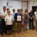 La directora general de Turismo, Comercio y Artesanía, Arantxa Pérez, ha inaugurado la exposición colectiva ‘Artesanía de Cuenca: tradición y excelencia’, que permanecerá abierta en la Sala Iberia de la capital conquense hasta el próximo 26 de julio. La muestra reúne los trabajos de casi una treintena de profesionales procedentes tanto de Cuenca como de localidades de la provincia como Las Pedroñeras, Belmonte, Villalpardo, Priego o Mota del Cuervo. El evento sirve para visibilizar la incorporación de nuevo talento al sector, materializada en la entrega de kits artesanos a las catorce personas que han obtenido su carné oficial entre 2024 y 2025. Durante la jornada, que ha incluido una visita al Centro de Oficios Artesanos Conquenses junto a miembros de la asociación provincial (APTACO), se ha subrayado la capacidad de estos creadores para mantener vivos los oficios tradicionales mientras los adaptan a las nuevas exigencias comerciales. Además, como medida de impulso y profesionalización, el Gobierno regional ha confirmado que la tercera edición del Máster de Artesanía comenzará este próximo mes de septiembre. Hemeroteca y cierre El archivo de Liberal de Castilla documenta el esfuerzo constante del tejido artesano conquense por no quedar relegado al pasado. A lo largo de los años, las páginas locales han recogido la trayectoria de oficios históricos como la alfarería de Mota del Cuervo, hoy representada por figuras como la cantarera Claudia Moreno, quien también ha participado en la jornada para compartir su experiencia vital ligada al barro. La reciente actualización del Repertorio de Oficios Artesanos de Castilla-La Mancha viene a dar respuesta a una demanda de modernización que asociaciones como APTACO llevan tiempo reivindicando en la prensa provincial. La inclusión de nuevas técnicas, sumada al respaldo para garantizar el relevo generacional, demuestra cómo el sector en Cuenca ha logrado evolucionar: ya no solo se trata de conservar un legado etnográfico, sino de consolidar una actividad económica competitiva que une el arraigo a los pueblos con el futuro del comercio.